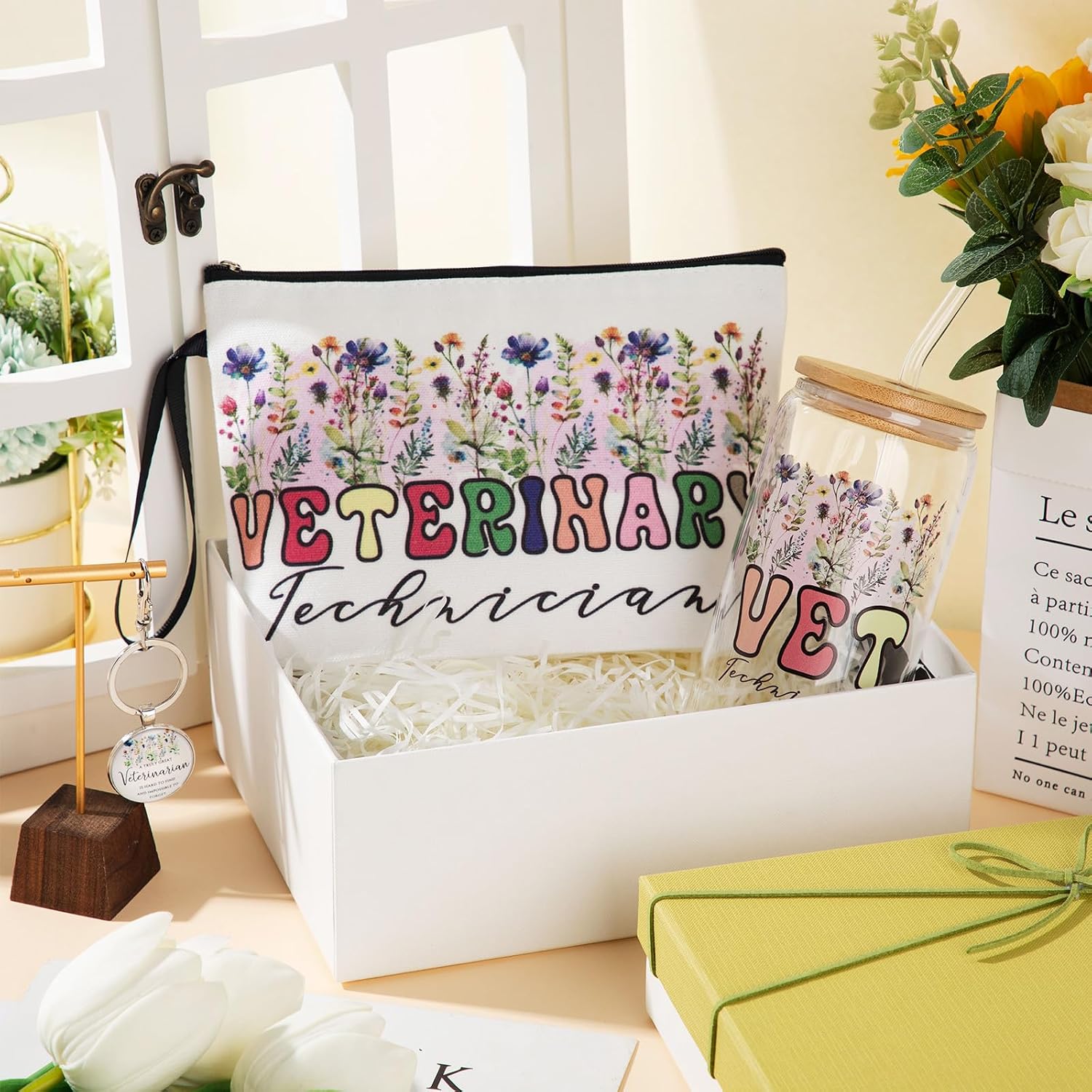 White gift box holding a floral Veterinary Technician makeup bag and a glass cup with a bamboo lid and straw, beside a Veterinarian keychain
