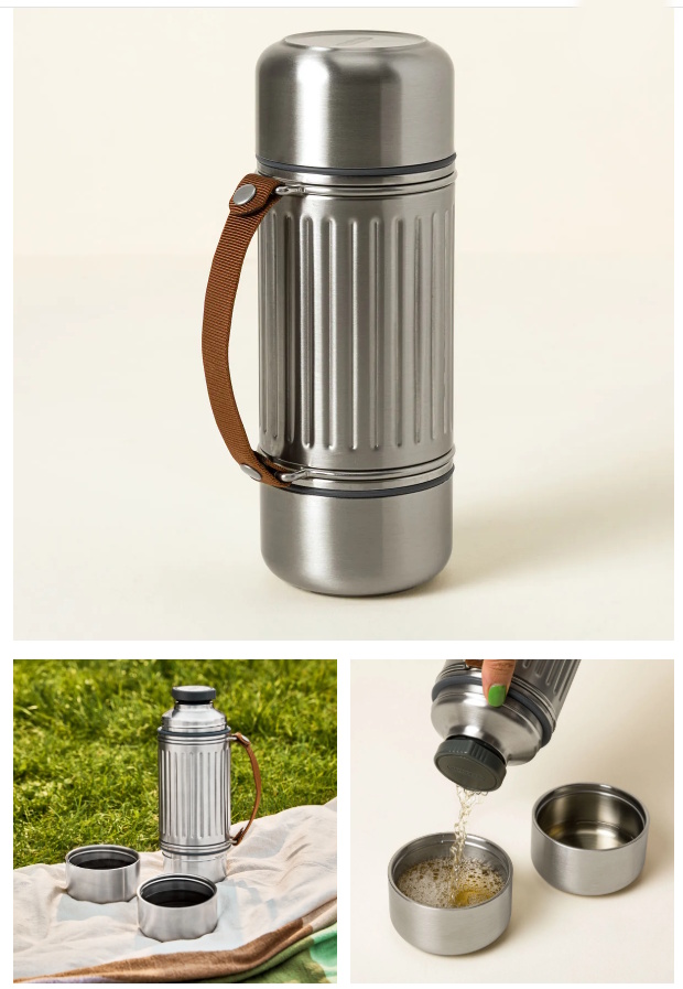 Brushed stainless steel insulated travel flask for two with brown leather carry strap, shown with two nesting stainless cups being poured out on a picnic blanket