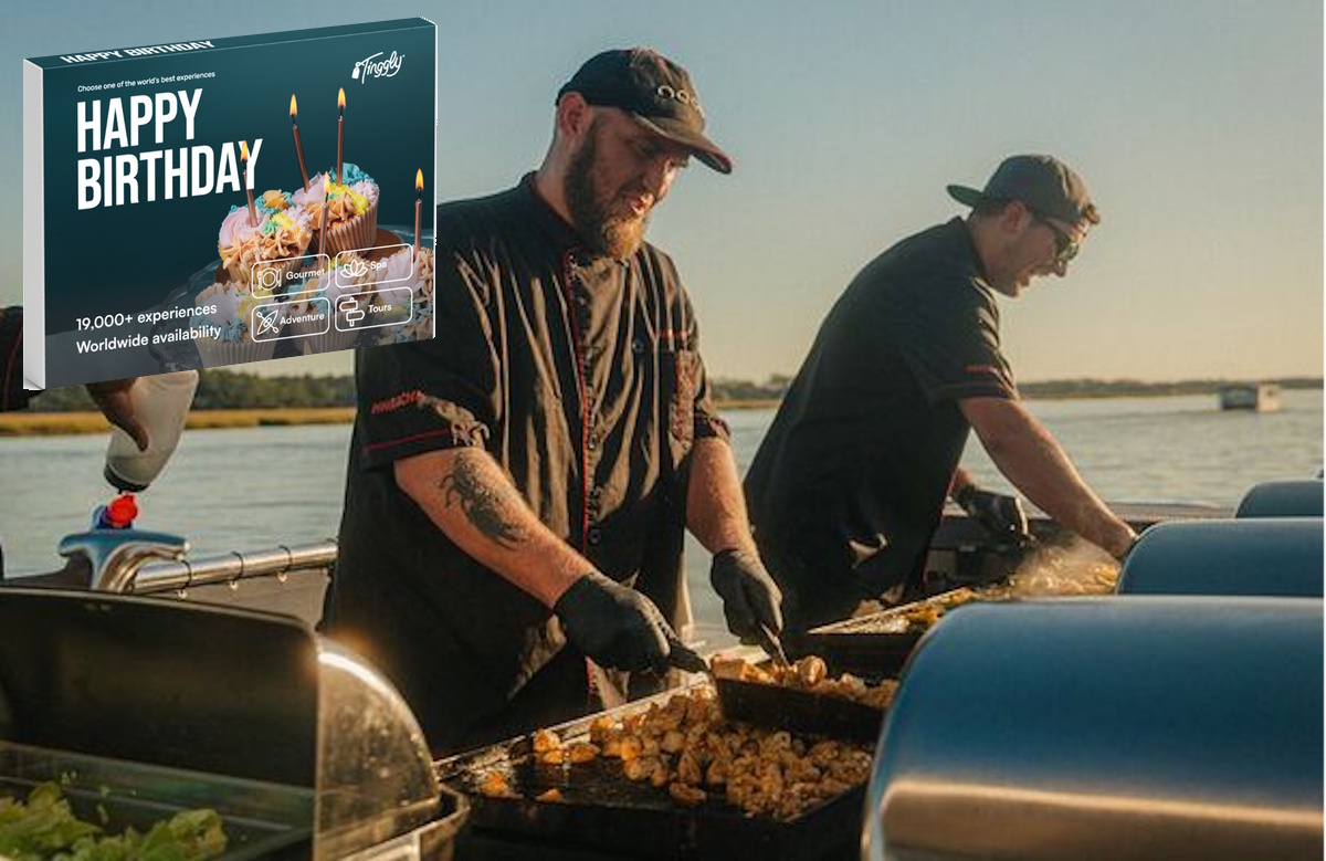 Tinggly Happy Birthday experience gift box shown in front of chefs cooking seafood on an outdoor griddle by the water