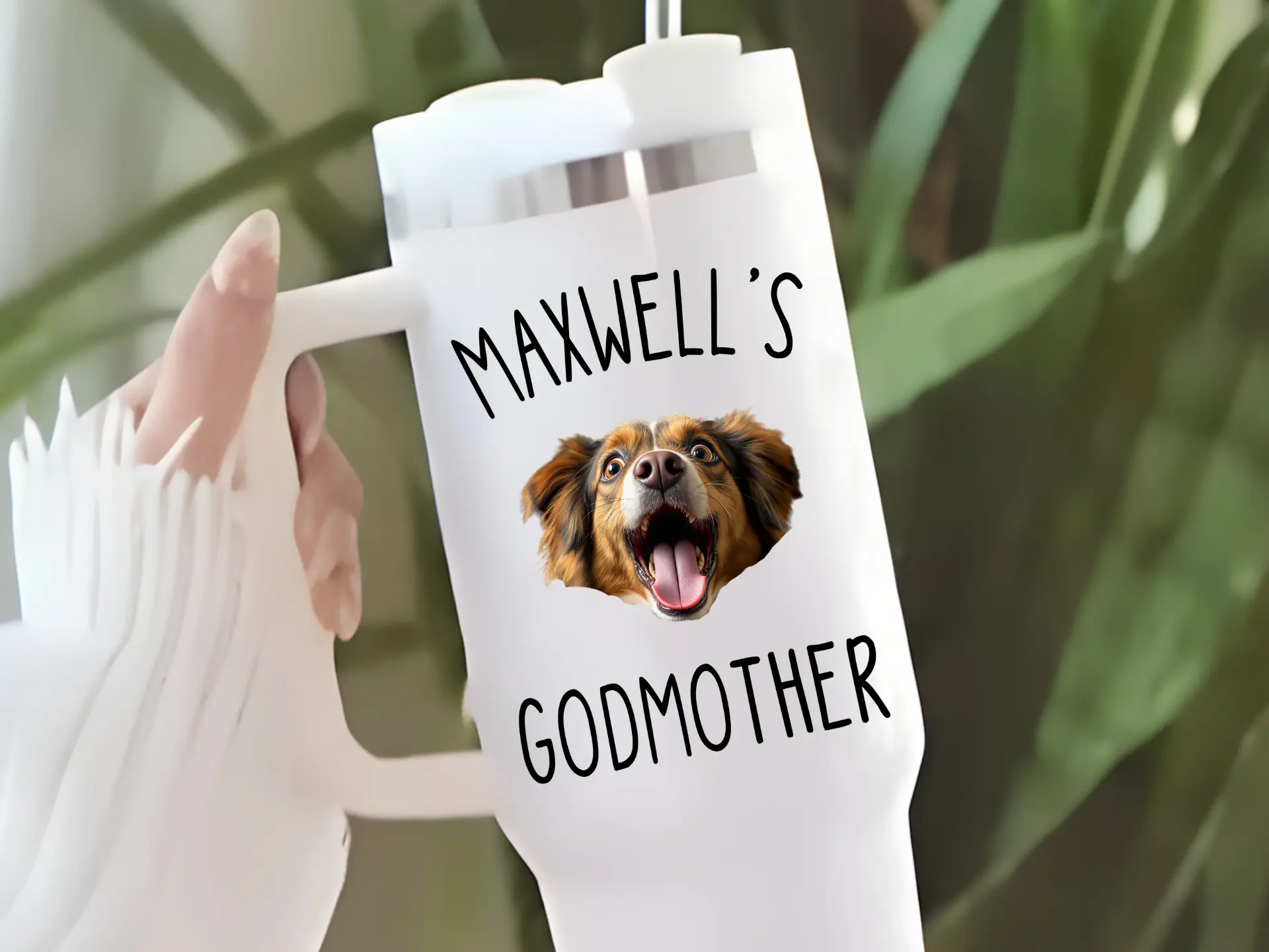 White 40 ounce handled tumbler with a straw, printed with Maxwell's Godmother around a photo of a happy brown and black dog