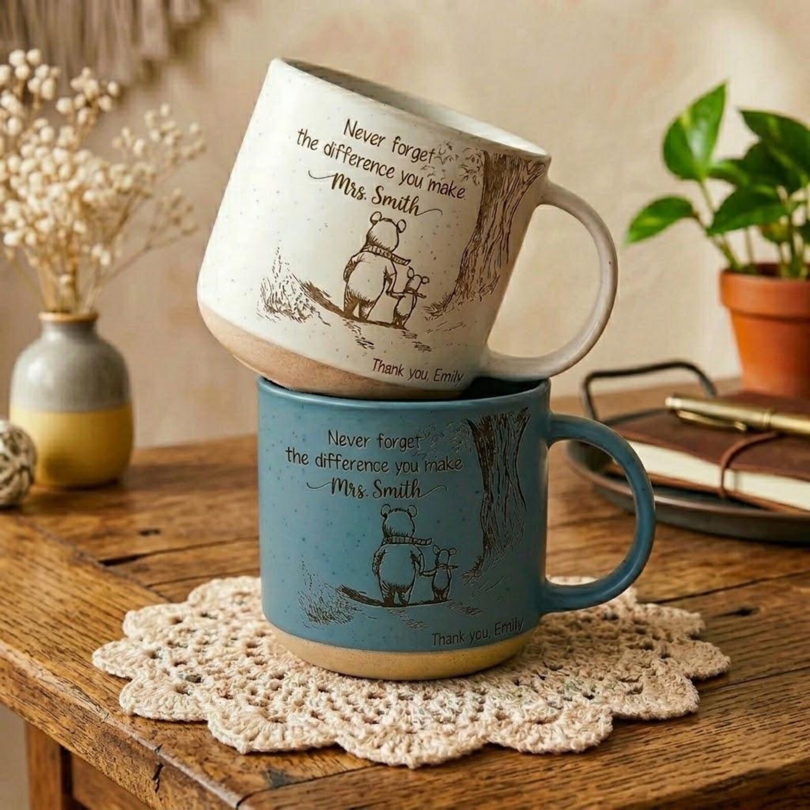 Two speckled artisan stoneware personalized daycare teacher thank-you mugs, one cream and one dusty blue, stacked on a rustic wood table with vintage bear illustration and hand-lettered 'Never forget the difference you make Mrs. Smith - Thank you, Emily' message