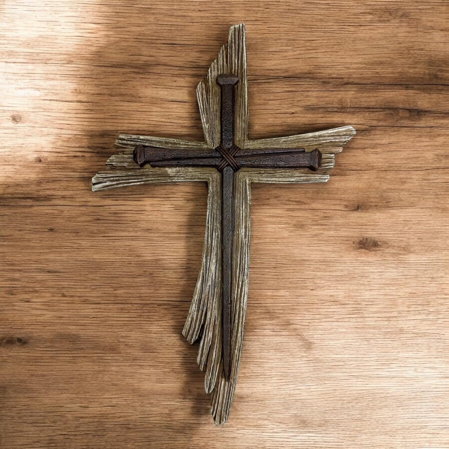 Twelve and a half inch wall cross with a layered weathered-wood look and dark iron nails forming a second cross at its center, mounted on a wood-panel wall
