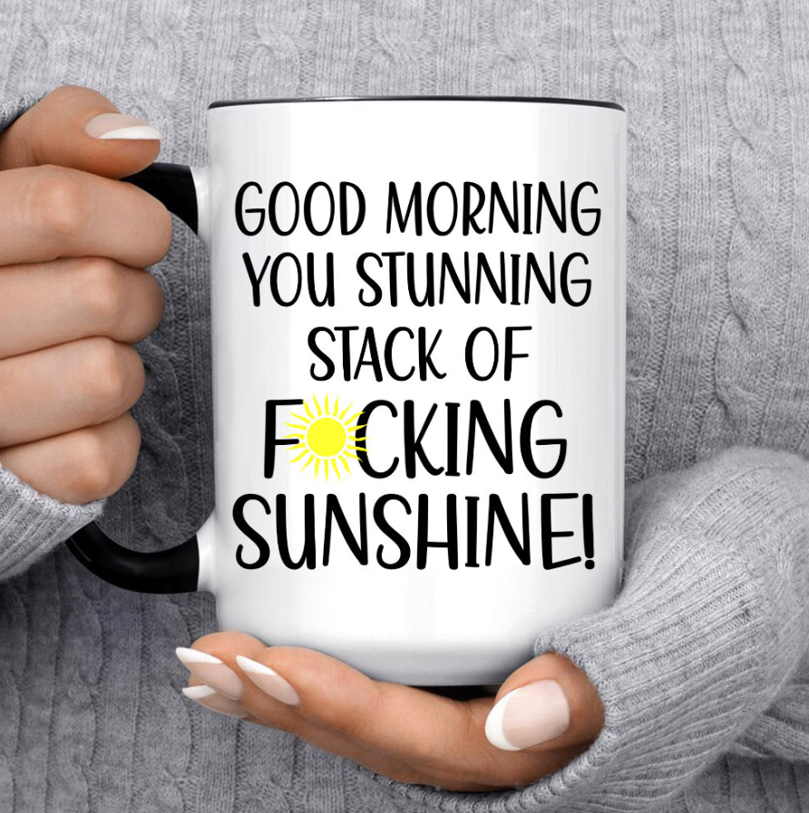 Large white ceramic mug with a black handle and interior, printed with Good Morning You Stunning Stack Of Sunshine and a yellow sun illustration